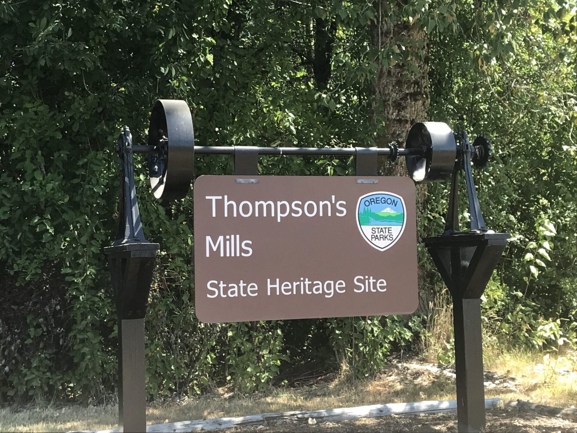 Entrance sign to Thompson's Mills State Heritage Site.  The sign is created from metalwork from the old mill works.