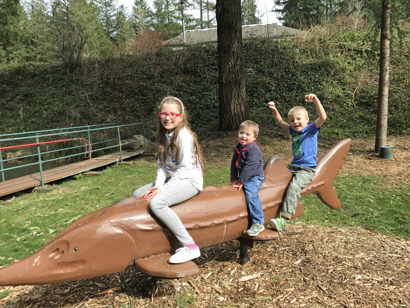 Children ride on a giant sturgeon statue.